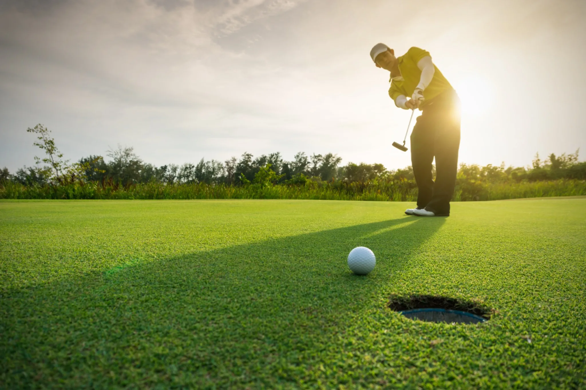 Golfer beim Putten auf dem Grün