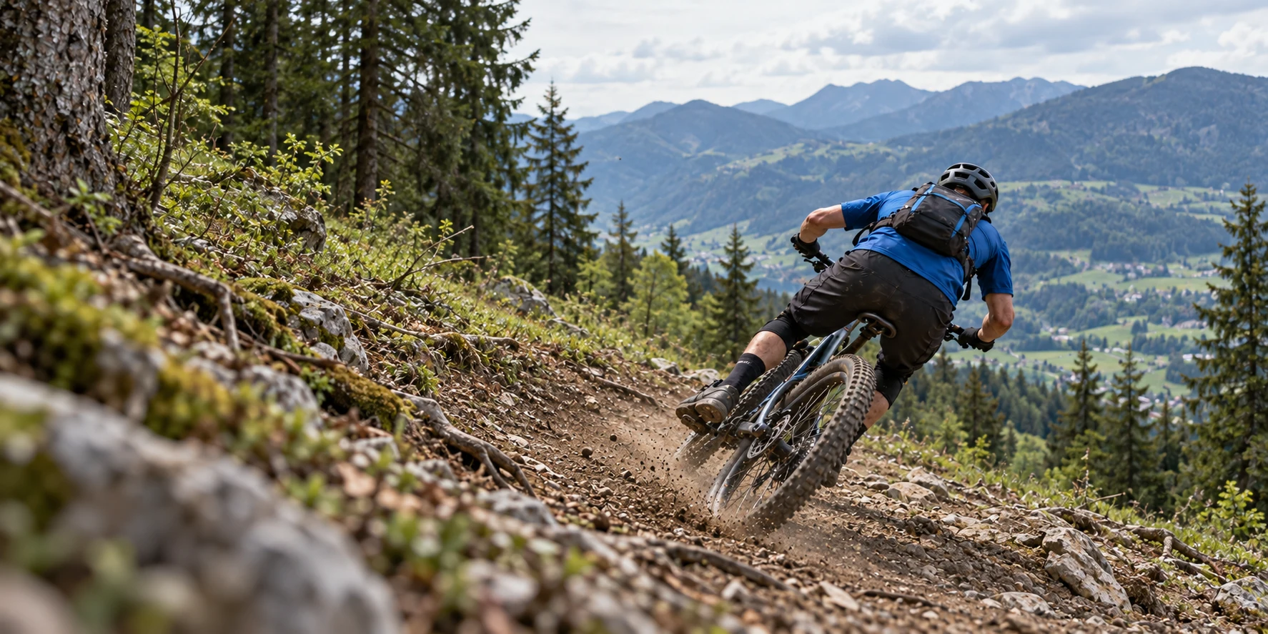 Mountainbiker in blauem Trikot auf einer Waldstrecke